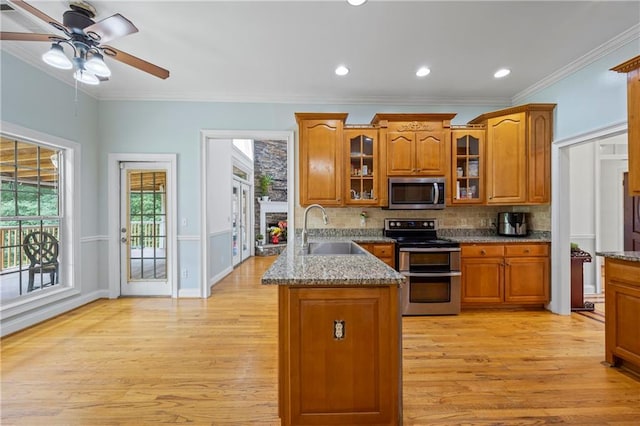 387 Lauren Marie Dr, Braselton, GA 30517 - kitchen featuring stainless steel appliances, a sink, brown cabinets, a peninsula, and light wood-style flooring