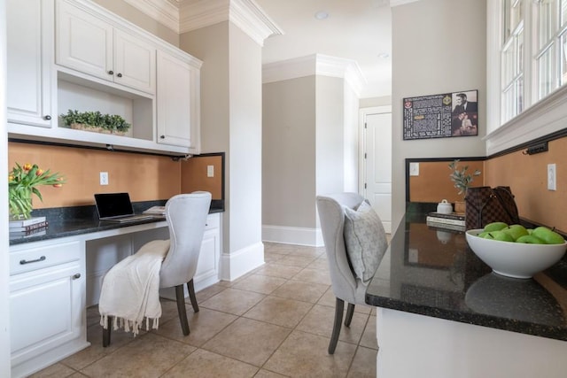 home office with light tile patterned floors, built in study area, baseboards, and ornamental molding