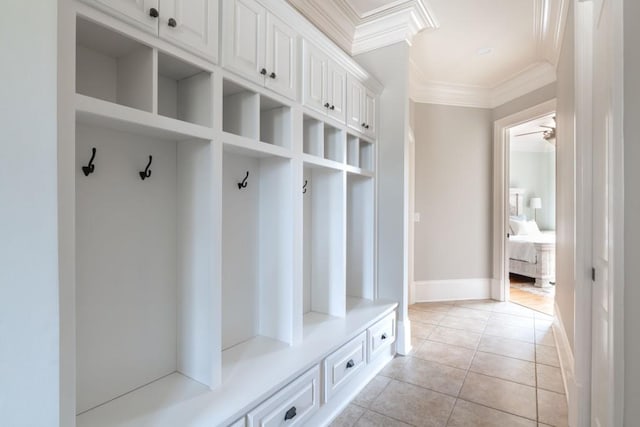 mudroom featuring crown molding, light tile patterned flooring, and baseboards