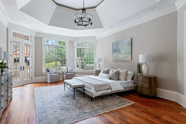 bedroom with a tray ceiling, french doors, crown molding, and access to outside