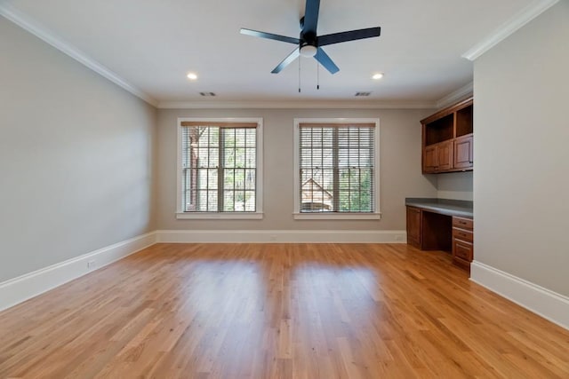 unfurnished living room with visible vents, crown molding, baseboards, light wood-type flooring, and built in study area