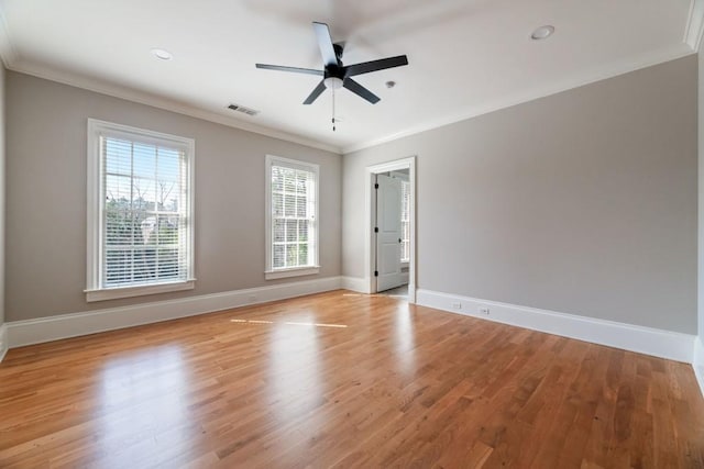 unfurnished room with visible vents, ceiling fan, baseboards, ornamental molding, and light wood-style floors