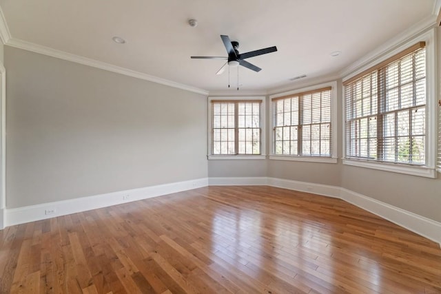 unfurnished room with ceiling fan, wood finished floors, baseboards, and ornamental molding