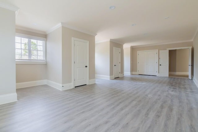 unfurnished room featuring light wood-style flooring, baseboards, and ornamental molding