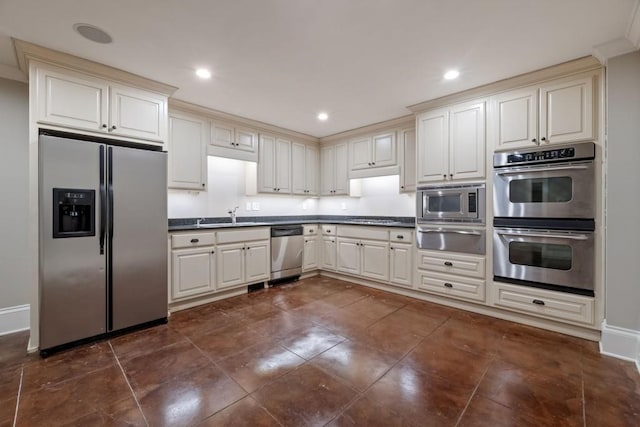 kitchen featuring a warming drawer, stainless steel appliances, dark countertops, and a sink