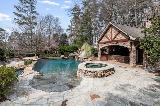 outdoor pool featuring a water slide, an in ground hot tub, and a patio area