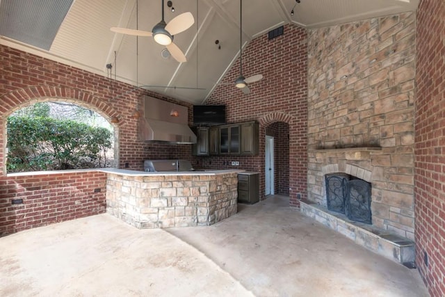 view of patio featuring ceiling fan, area for grilling, grilling area, and an outdoor stone fireplace