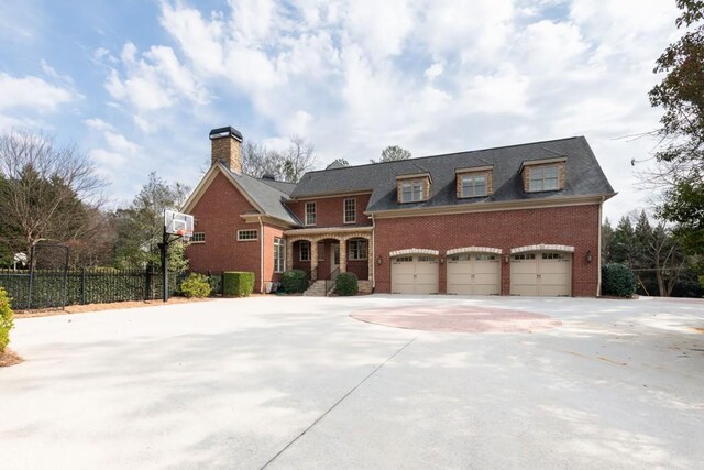 view of front facade featuring a garage, brick siding, concrete driveway, and fence