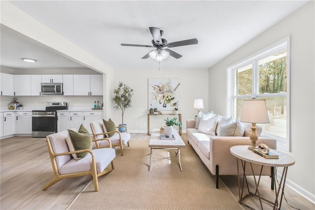 living room featuring ceiling fan and light hardwood / wood-style flooring