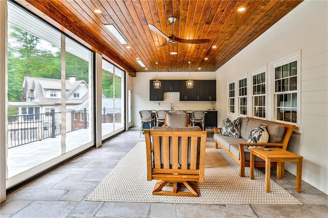 sunroom featuring wood ceiling, stone tile floors, and recessed lighting