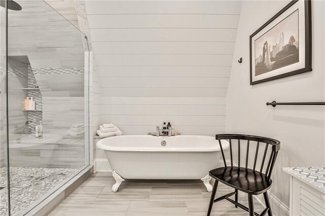 bathroom with a freestanding bath, baseboards, and a stall shower