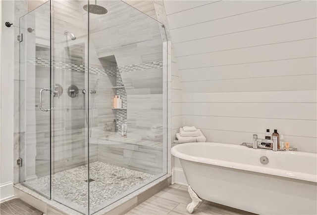 bathroom featuring a shower stall and a freestanding tub