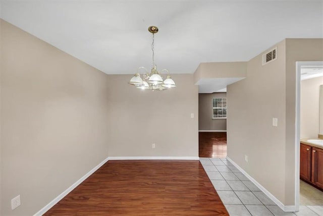 4701 Flat Shoals Rd Unit 37H, Union City, GA 30291 - unfurnished dining area featuring a chandelier, baseboards, and light wood-style floors