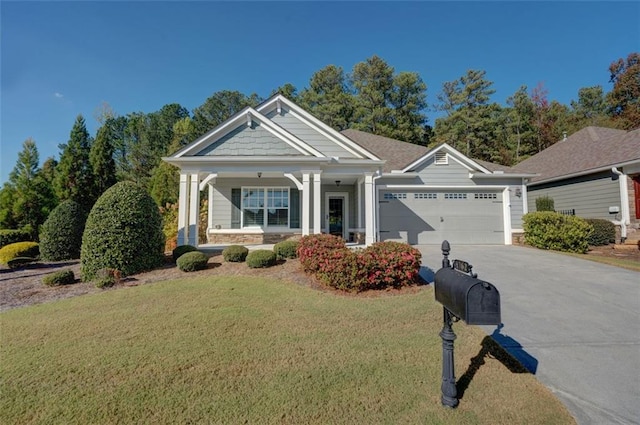 craftsman-style house featuring covered porch, a front lawn, and a garage