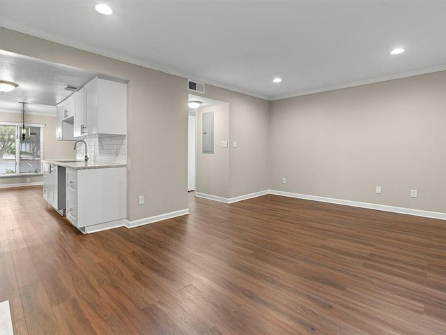 95 Ivy Trl NE, Atlanta, GA 30342 - unfurnished living room featuring crown molding, dark wood finished floors, a sink, recessed lighting, and baseboards