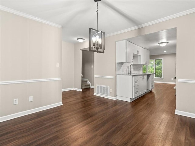 95 Ivy Trl NE, Atlanta, GA 30342 - unfurnished dining area featuring dark wood-style floors, baseboards, a chandelier, stairs, and crown molding
