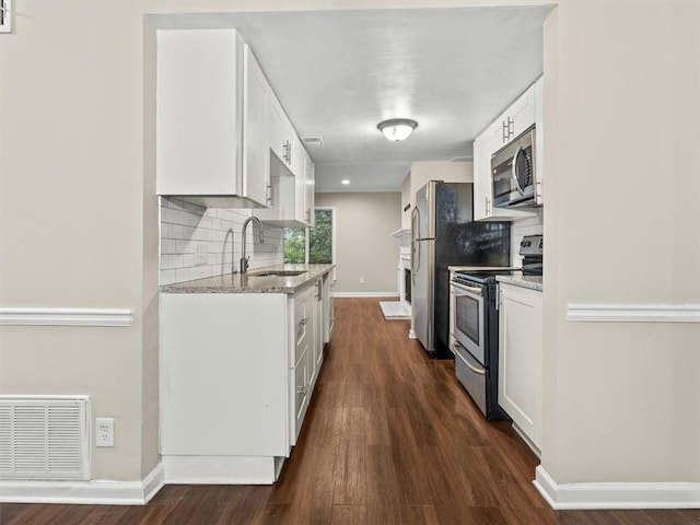 95 Ivy Trl NE, Atlanta, GA 30342 - kitchen featuring appliances with stainless steel finishes, a sink, baseboards, dark wood-style flooring, and backsplash