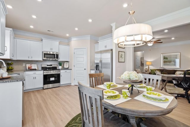 dining space featuring light wood finished floors, visible vents, recessed lighting, and crown molding