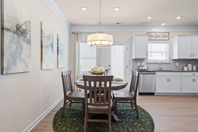 dining space with visible vents, baseboards, light wood finished floors, recessed lighting, and ornamental molding