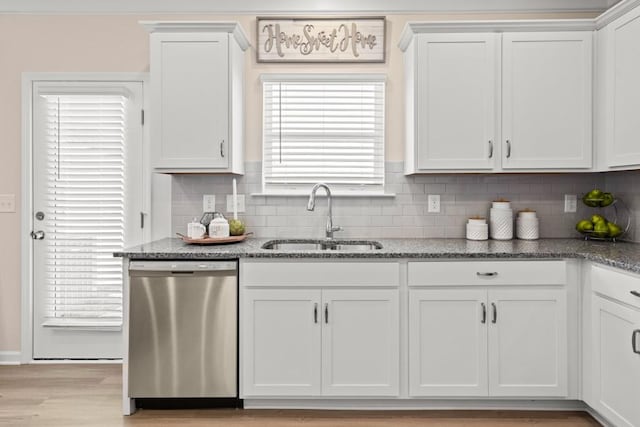 kitchen with light wood-style flooring, a sink, stone countertops, stainless steel dishwasher, and white cabinets