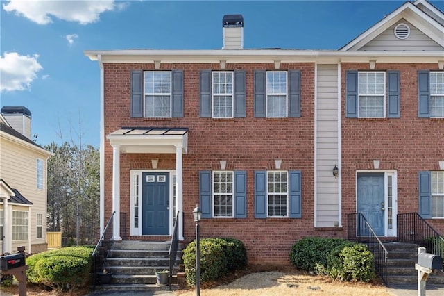 multi unit property with brick siding and a chimney