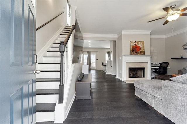 foyer entrance featuring stairway, dark wood-style flooring, a high end fireplace, and crown molding