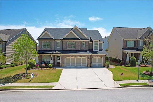 craftsman house featuring an attached garage, driveway, a front yard, and brick siding