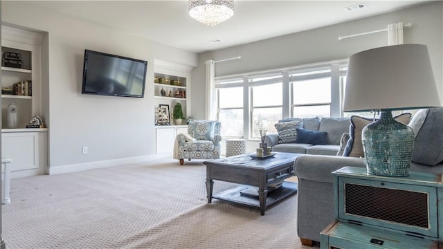 living room with visible vents, built in features, baseboards, a notable chandelier, and carpet
