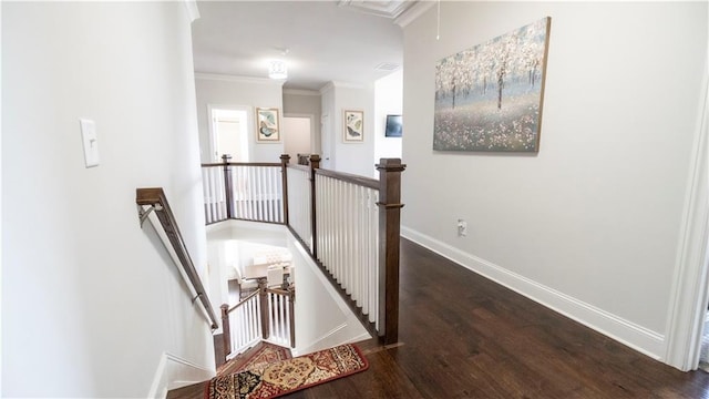 hallway with an upstairs landing, baseboards, and wood finished floors