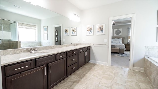 ensuite bathroom with a sink, a ceiling fan, connected bathroom, and double vanity