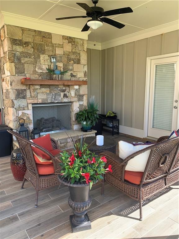 exterior space featuring a ceiling fan and a stone fireplace