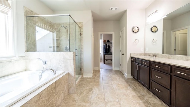 715 Laura Jean Ct, Buford, GA 30518 - bathroom featuring vanity, a bath, a stall shower, a walk in closet, and baseboards