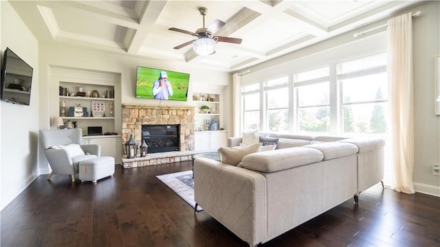 living room with built in features, baseboards, a ceiling fan, a fireplace, and dark wood finished floors