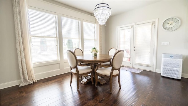 dining room with an inviting chandelier, baseboards, plenty of natural light, and dark wood-style flooring