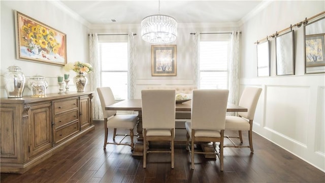 dining area with a decorative wall, ornamental molding, an inviting chandelier, and dark wood-style floors