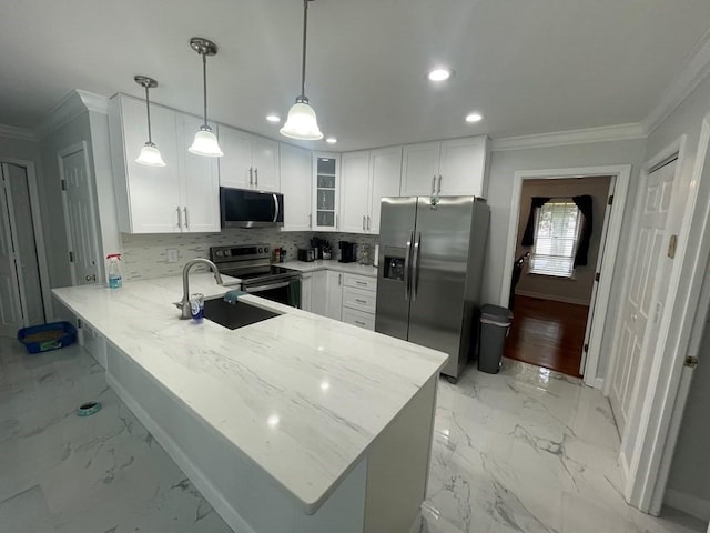 kitchen featuring kitchen peninsula, stainless steel appliances, ornamental molding, decorative light fixtures, and white cabinetry