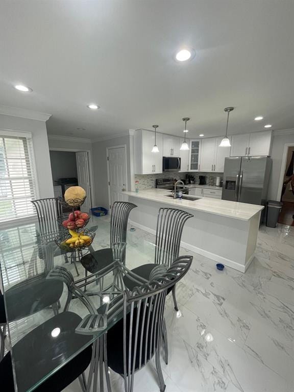 dining room with sink and crown molding