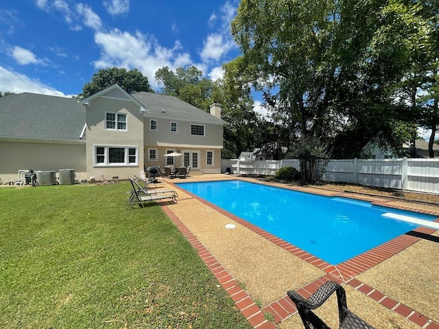 view of swimming pool featuring central AC, a yard, and a diving board