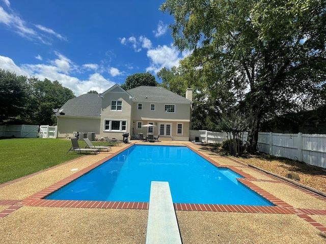 view of pool featuring a patio area, a diving board, and a lawn