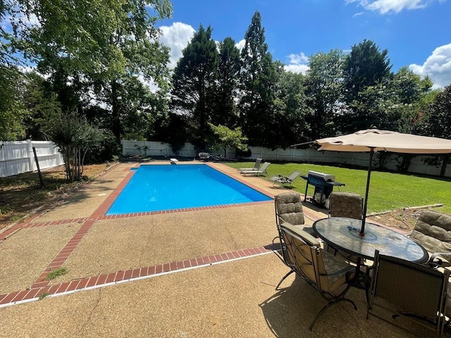 view of swimming pool featuring a patio, a yard, and a diving board