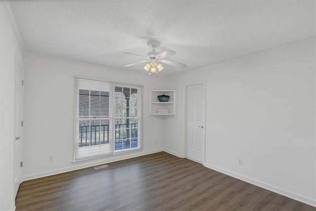 spare room with a textured ceiling, ceiling fan, ornamental molding, and dark wood-type flooring