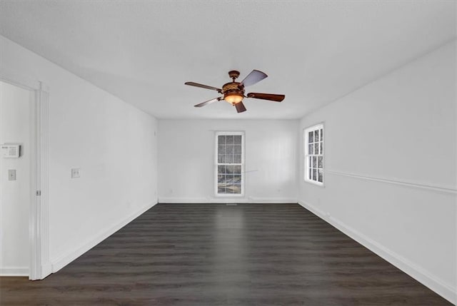 empty room with dark hardwood / wood-style flooring and ceiling fan