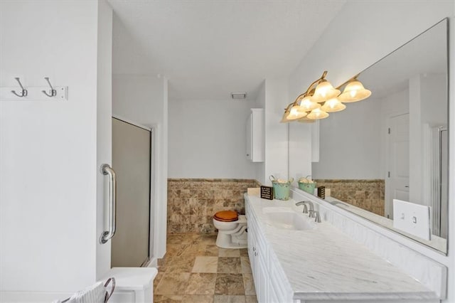 bathroom with vanity, toilet, and a shower with door