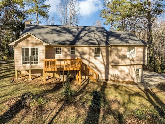 rear view of property with a deck and a yard