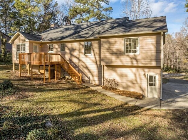 rear view of property with a lawn and a deck