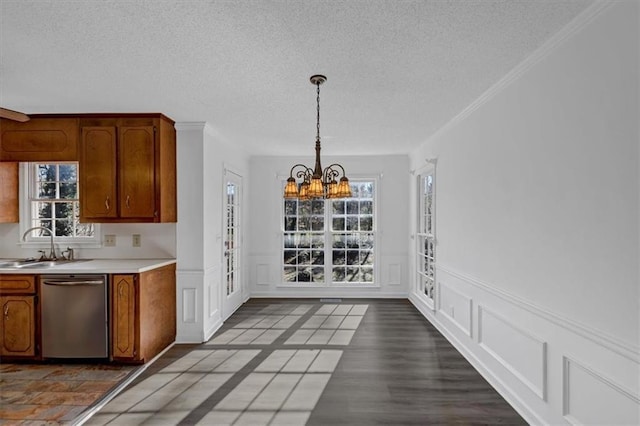 kitchen featuring stainless steel dishwasher, crown molding, sink, decorative light fixtures, and a notable chandelier