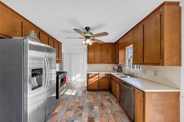 kitchen featuring ceiling fan, sink, and stainless steel appliances