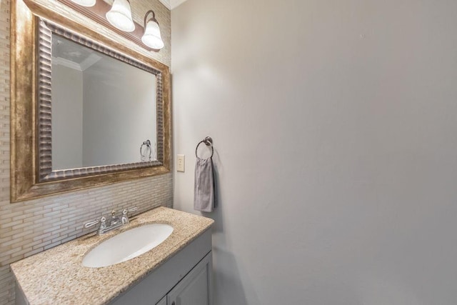 bathroom with decorative backsplash, vanity, and ornamental molding