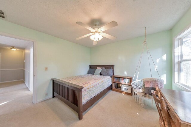 carpeted bedroom with multiple windows, a textured ceiling, and ceiling fan