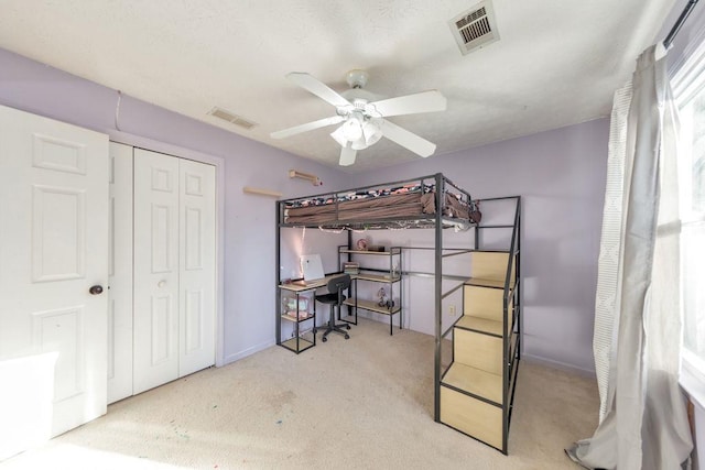 bedroom with ceiling fan, carpet floors, and a closet